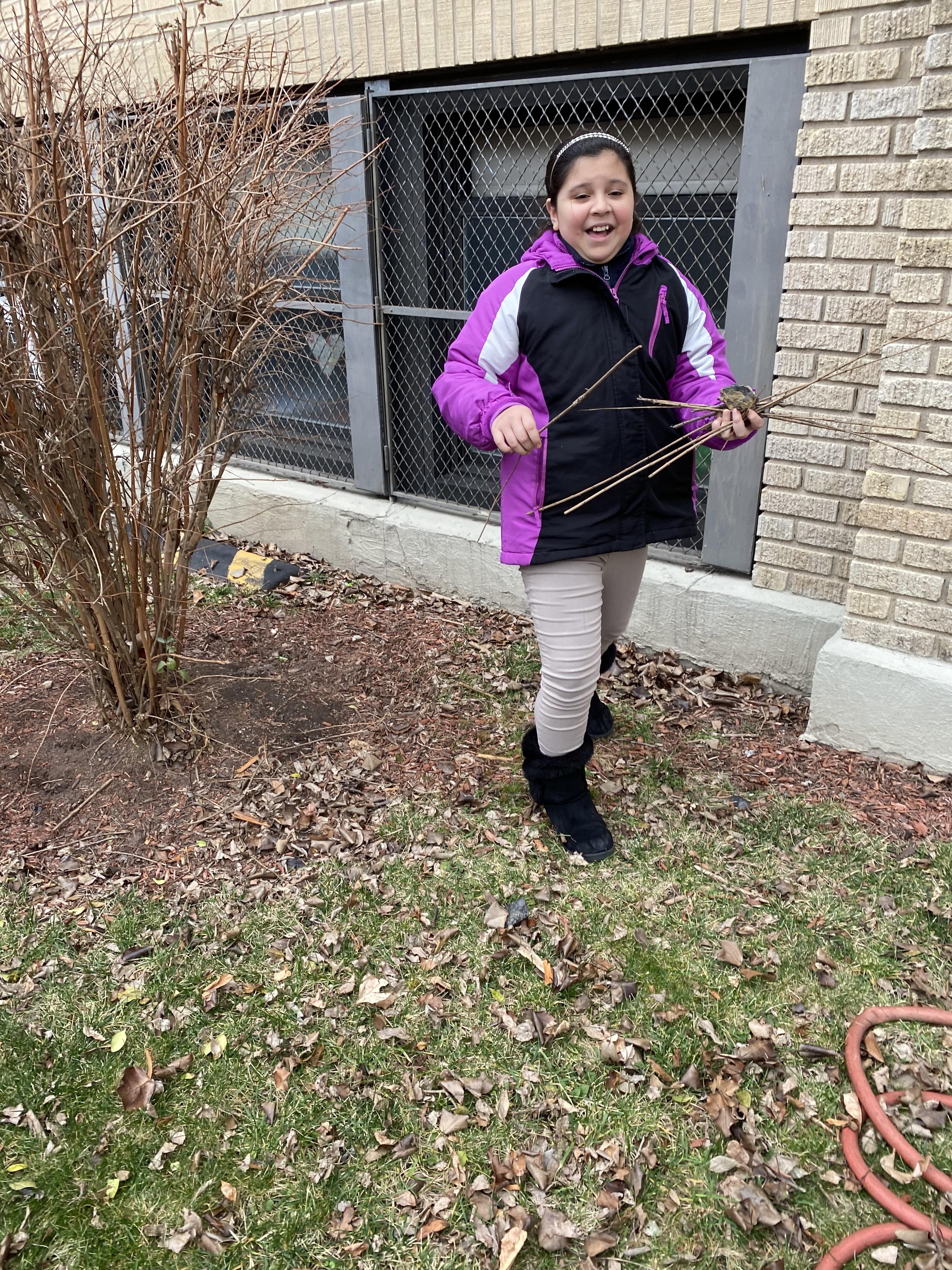 girl showing off her collected twigs