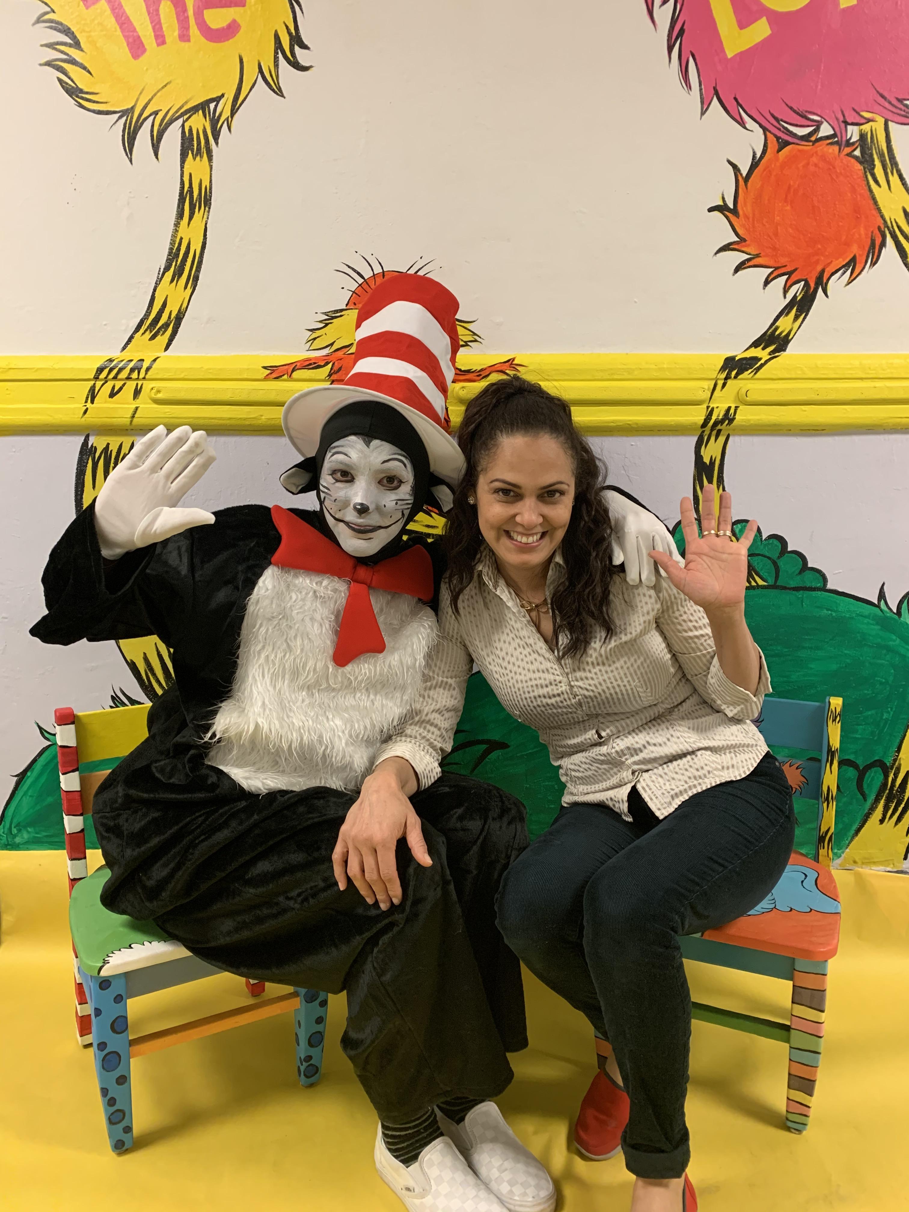 cat in the hat seated next to teacher